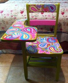 two colorful chairs sitting next to each other in front of a bed