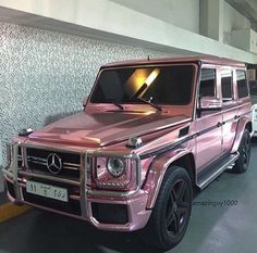 a pink mercedes g - class parked in a garage