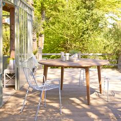 an outdoor table and chairs on a deck