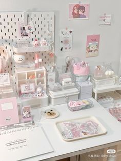 there are many items on the desk in this office setting, including pink and white accessories