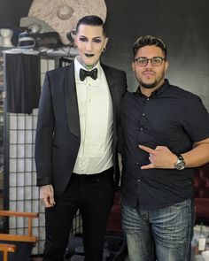 two men standing next to each other in front of a mannequin