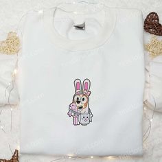 Introducing the Bingo Easter Embroidered Shirt, a must-have for the fashion-forward crowd. Made with premium quality fabric, this shirt features intricate embroidery of the Easter Bunny and eggs, adding a playful touch to your outfit. The comfortable fit and soft texture ensure all-day comfort. Get ready to turn heads and spread joy this Easter! Elevate your little one’s wardrobe with the Bluey Cartoon Embroidered Hoodie. Crafted with utmost care, this hoodie showcases a vibrant Bluey cart Thanksgiving Gift Ideas, Bluey Cartoon, Cartoon Hoodie, Maroon Hoodie, Embroidered Shirts, Hoodie Material, Thanksgiving Gift, Blue Sweatshirt, Embroidered Hoodie