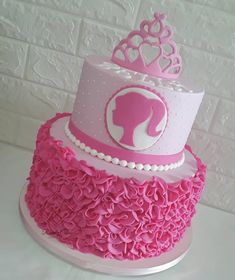 a pink and white cake with a tiara on top