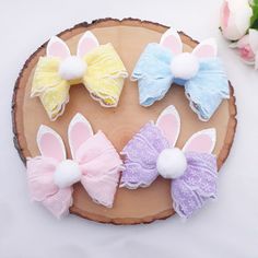 four little bunny ears are sitting on top of a piece of wood with flowers in the background