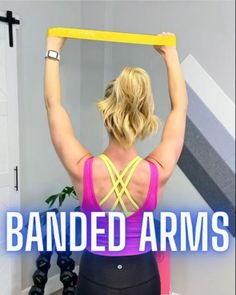 a woman holding up a yellow object with the words banded arms above her head