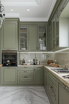 a large kitchen with green cabinets and marble counter tops, along with a chandelier hanging from the ceiling