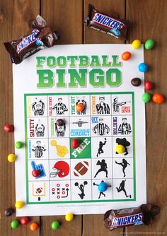 a football game is shown with candy and candies on the wooden table next to it