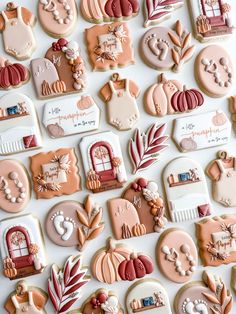 many decorated cookies are displayed on a white surface with autumn leaves and pumpkins in the background