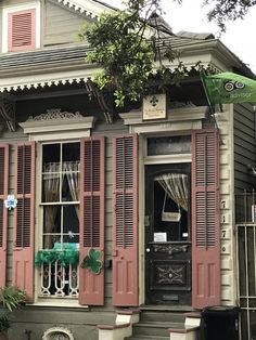 an old house with red shutters and green flags on the front door is decorated for st patrick's day