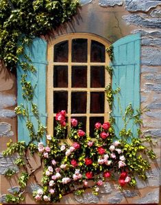 an old window with blue shutters and flowers on the outside is painted red, white and pink