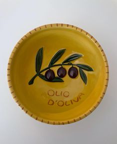 a yellow bowl with olives painted on it