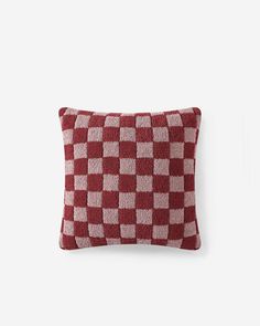 a red and white checkered pillow on a wall