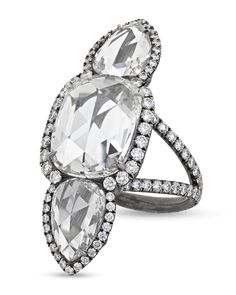 an oval and pear shaped diamond ring set in 18k white gold with diamonds surrounding the band