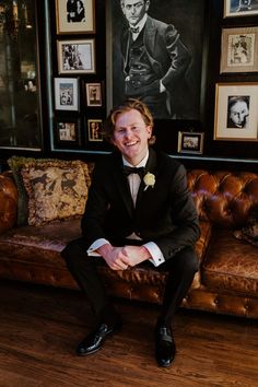 a man in a tuxedo is sitting on a couch and smiling at the camera