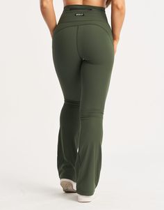 the back view of a woman in green yoga pants with her hands on her hips