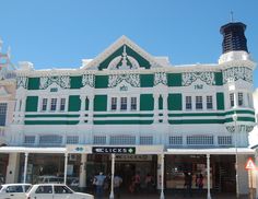 a green and white building with people standing outside