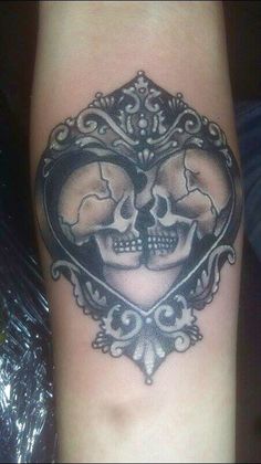 a couple of skulls in the shape of a heart on someone's leg,