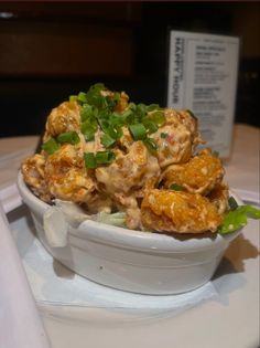 a white bowl filled with food on top of a table