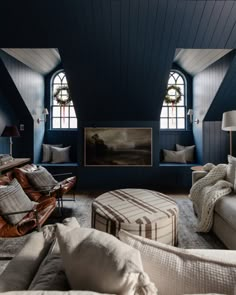 a living room filled with furniture and two large windows in the wall next to each other