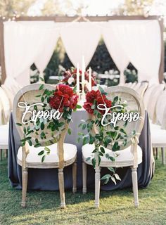 two chairs with flowers on them sitting in the grass