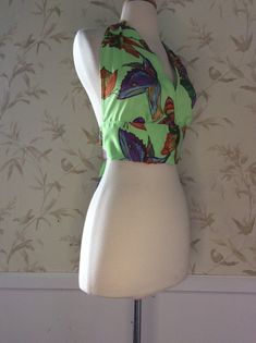 Halter Top 1970's Vintage Style Halter Top from a pattern I made from a True 70's Vintage Halter The Fabric is 1970's Vintage Fabric in an Amazing Butterfly Print  A polyester Crepe fabric. No stretch to it This will not be a True OOAK, as I have a bit more of this fabric The tag on the original Halter said one size fits all, but I don't think suitable for a large breast Please refer to photo with tape measure for fit Tape is placed at center of back neck to see where it lays below the breast The other is placed at center of bust to see side coverage I am only shipping Priority at this time. Have had too many issues with First Class Mail. Vintage items are Unique and Often one of a Kind. No fear of seeing a carbon copy of what you're wearing on someone else. Most often previously Worn and Fitted Green Floral Print Crop Top, Green Beachwear Crop Top For Spring, Green Crop Top For Spring Beachwear, Sleeveless Tropical Print Halter Top For Spring, Fitted 70s Inspired Tops For Summer, Fitted 70s Inspired Summer Tops, Retro Sleeveless Crop Top For Beach, Summer Green Halter Top With Floral Print, Fitted Green Halter Top For Swimming