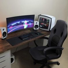 a computer desk with a monitor, keyboard and speakers