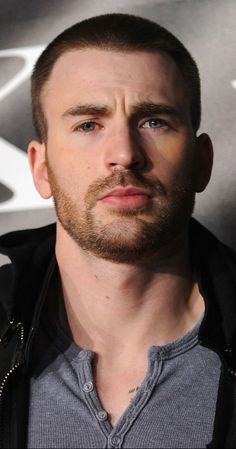 a close up of a person wearing a jacket and looking at the camera with a serious look on his face