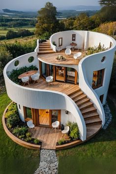 an aerial view of a circular home with stairs leading to the upper floor and second story