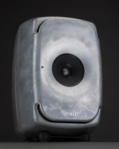 a close up of a speaker on a black surface with the word genele written below it