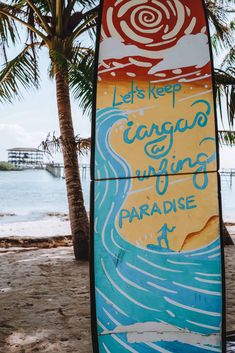 a surfboard with the words let's keep canggu surfing paradise written on it