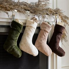 three christmas stockings hanging from a mantel