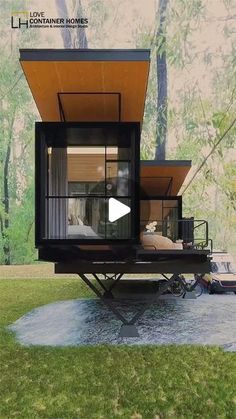 a tiny house is sitting in the middle of a field with trees and grass behind it