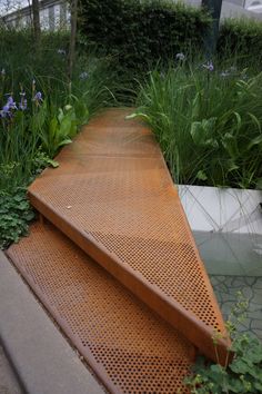 a wooden bench sitting in the middle of a garden