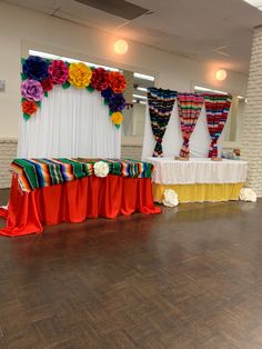 an empty room with colorful decorations on the wall and wooden flooring in front of it