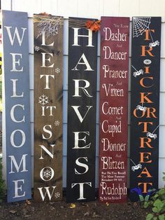 several wooden signs are lined up in front of a house