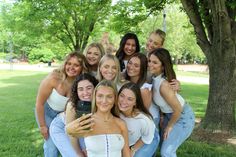 a group of women taking a selfie in front of a tree on a sunny day