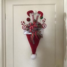 a door decorated with candy canes and santa hat hanging from the side of it