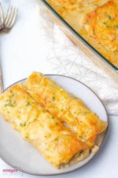 two slices of cheesy bread on a plate next to a casserole dish