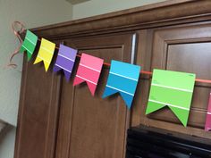 colorful paper buntings are hanging from the kitchen cabinets