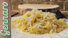 a white plate topped with pasta covered in cheese