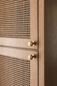 a wooden cabinet with metal handles and perfored design on the front, along with brass knobs