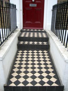 black and white tiled steps leading to a red door