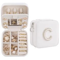 an open white jewelry box with rings and bracelets