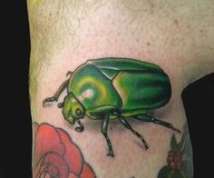 a close up of a green bug on the side of a man's leg