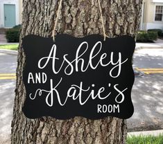 a sign hanging from the side of a tree in front of a house that says, astley and kate's room