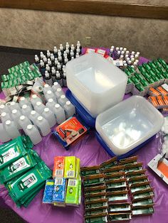 the table is covered with many bottles and containers of toothpaste, soaps, and dental floss