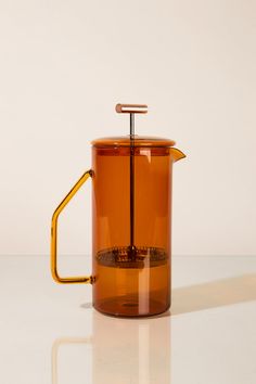 a yellow glass coffee pot with a handle