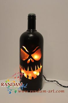 a bottle with a glowing jack - o - lantern face on it