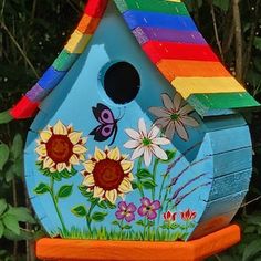 a colorful birdhouse with flowers and butterflies painted on it