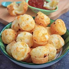 a bowl filled with mini pizzas next to a small bowl of ketchup